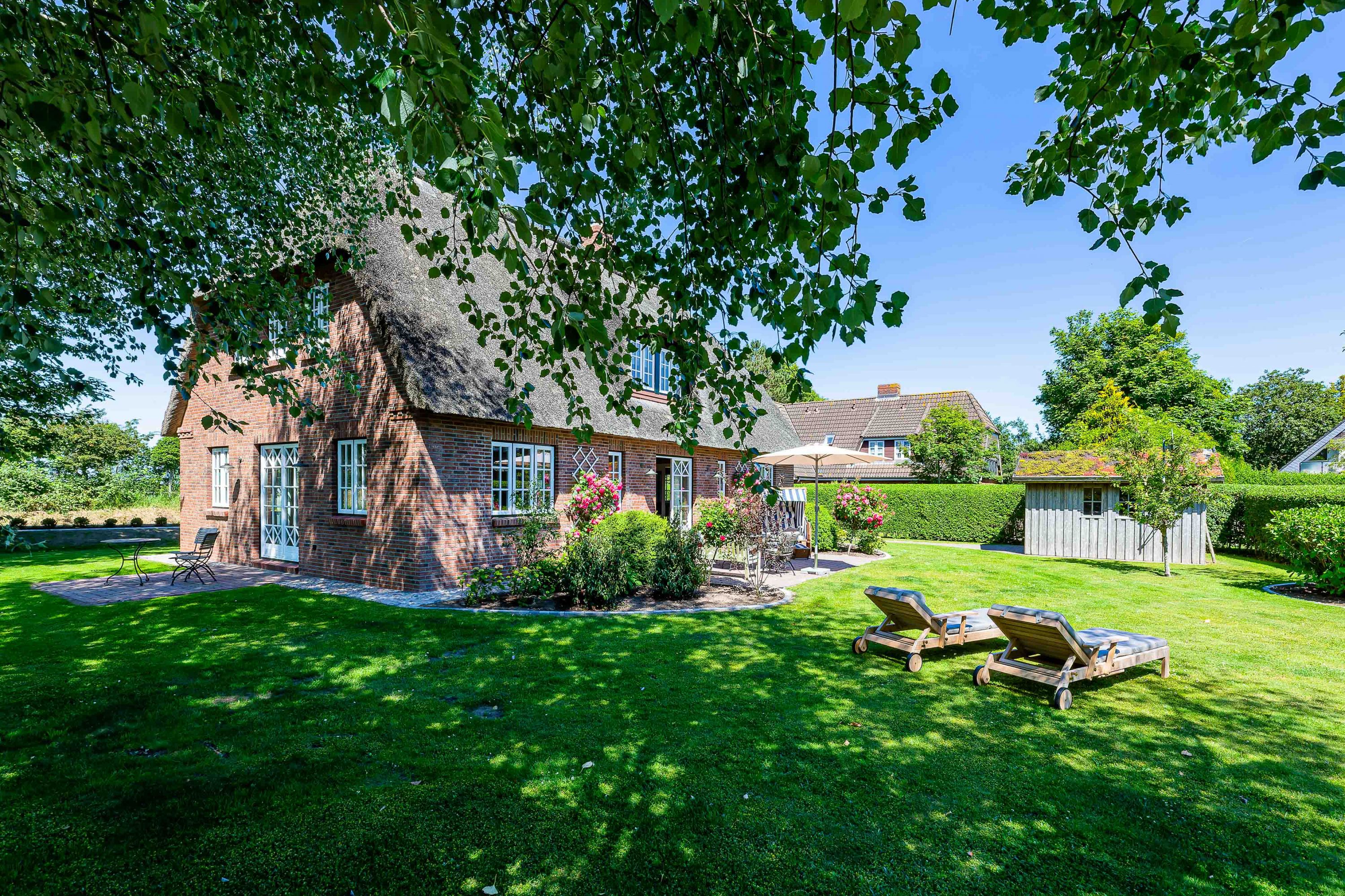 Großer Garten rund um das reetgedeckte Landhaus