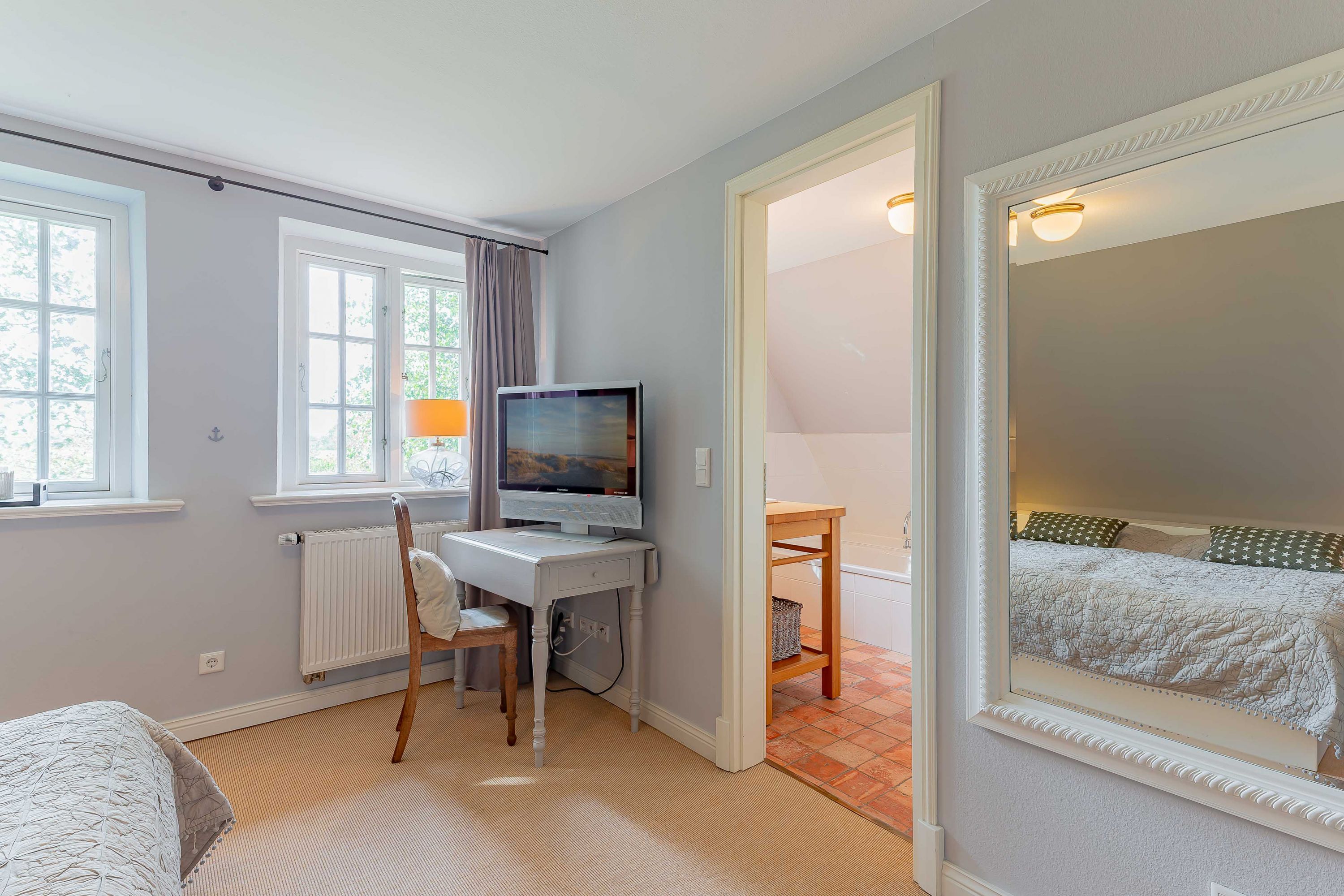 Schlafzimmer mit kleinem Arbeitsplatz und Blick ins Grüne