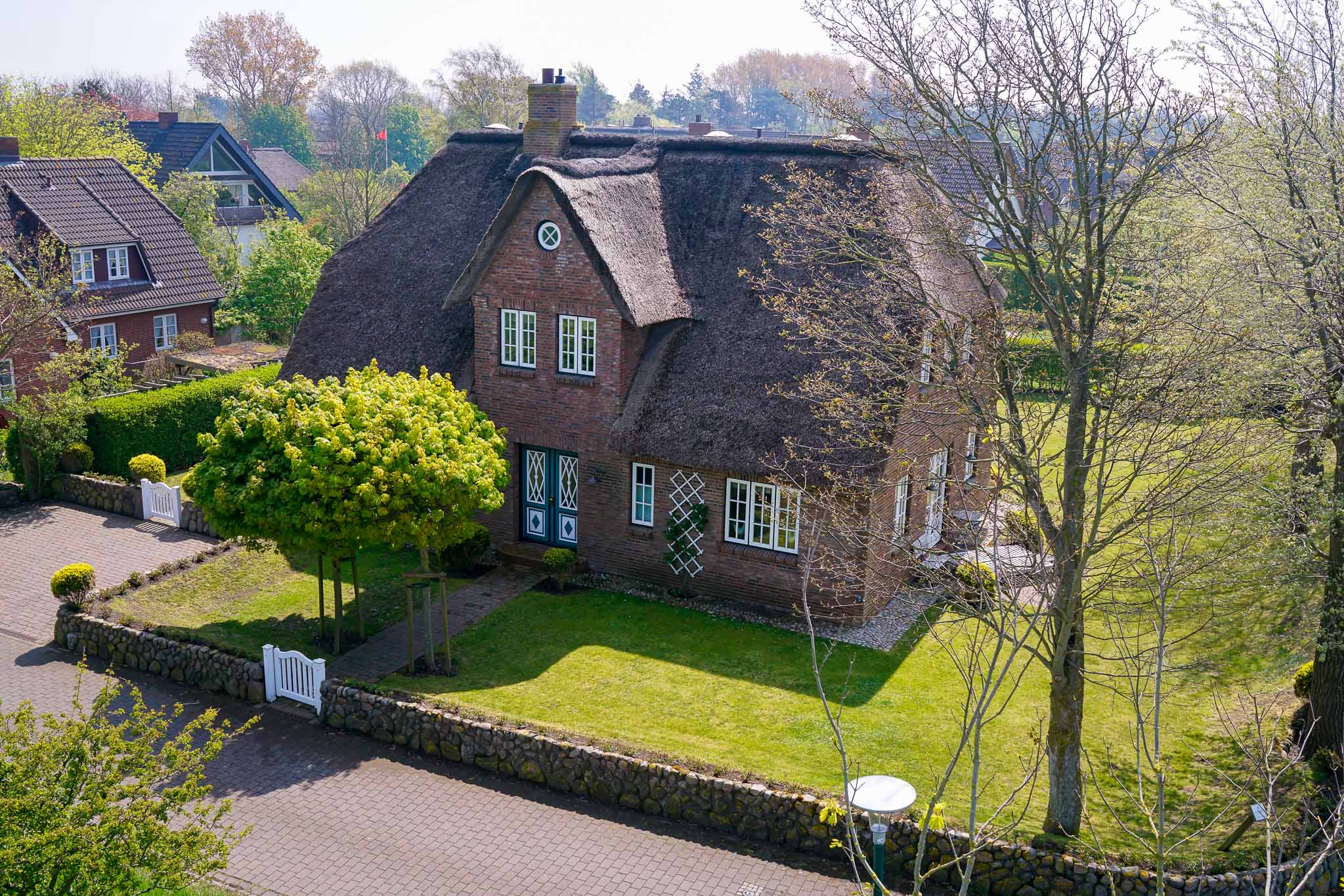 Das reetgedeckte Landhaus aus erhöhter Perspektive
